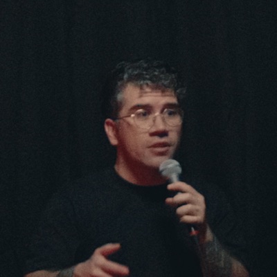 Jarrod Kane performing on stage with a microphone