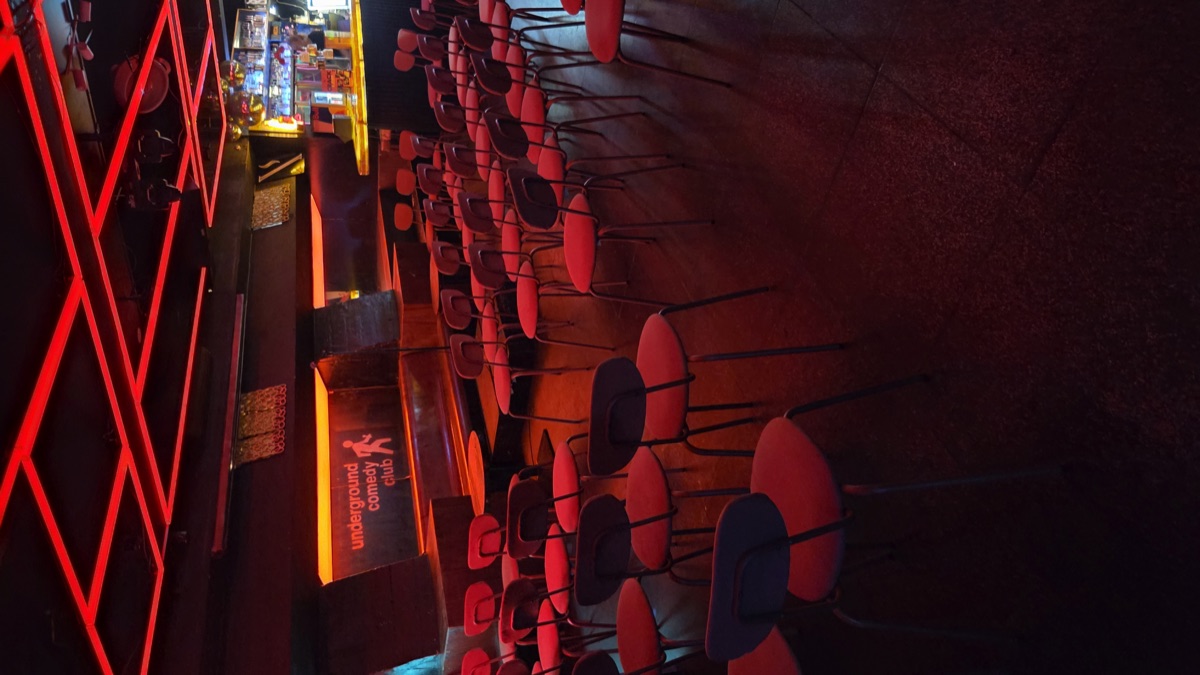 The comedy room with rows of red chairs facing the stage